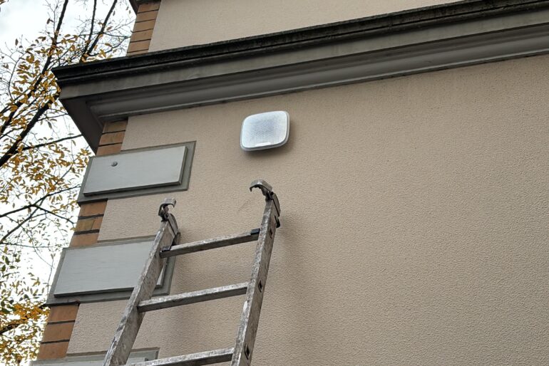 Leiter an einer Fassade unterhalb einer montierten Sicherheitskomponente