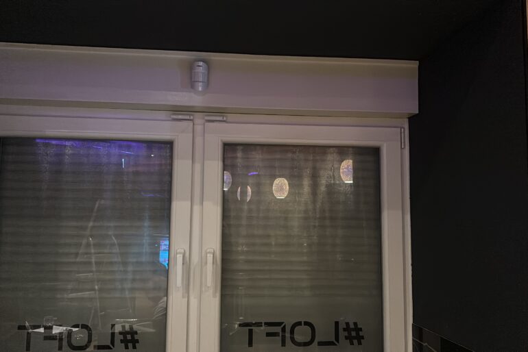 Montierte Alarmkomponenten oberhalb einer Fensterfront