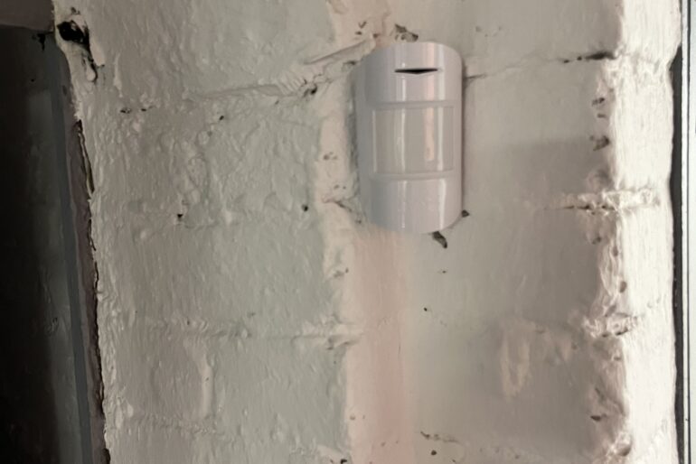Montierter Melder an einer hell gestrichenen Backsteinwand