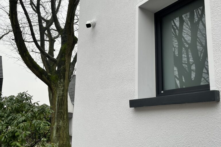 Montierte Außensirene an einer Fassade neben einem Fenster