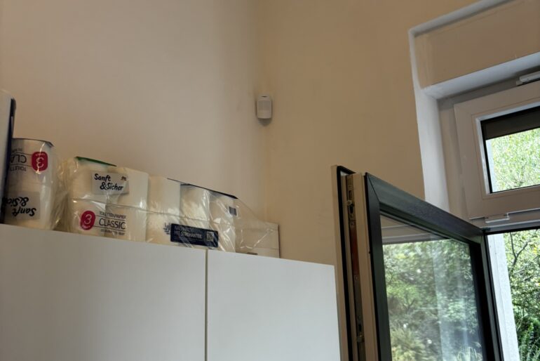Montierter Melder an einer Innenwand neben einem Fenster