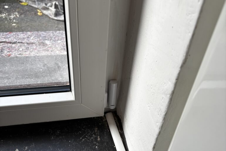 Montierter Melder neben einem Fenster in einem Innenraum