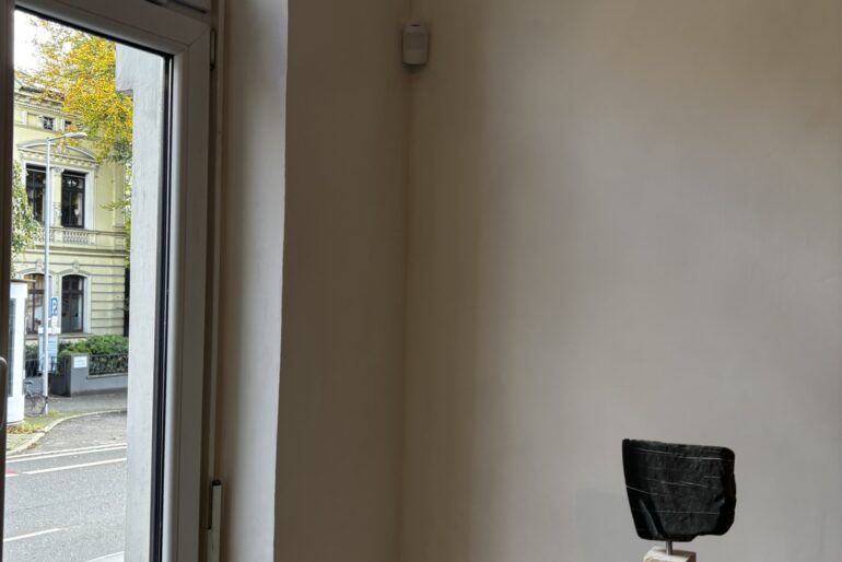 Montierter Bewegungsmelder an einer Innenwand neben einem Fenster