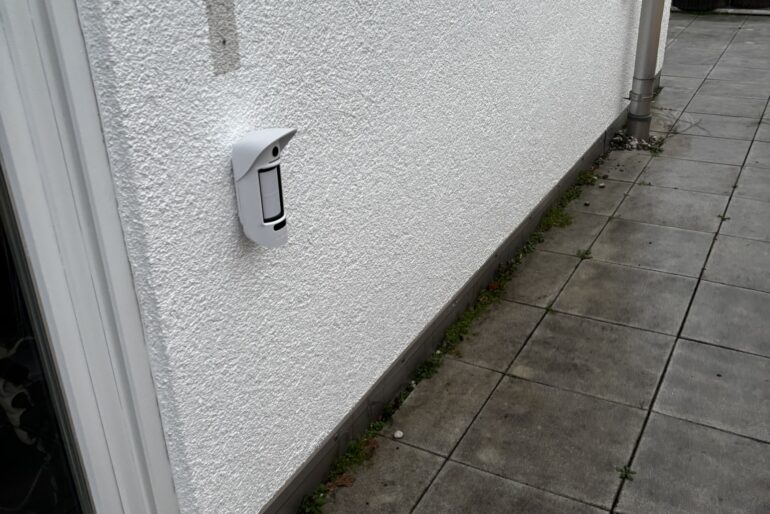 Montierte Alarmkomponente an einer hellen Außenwand