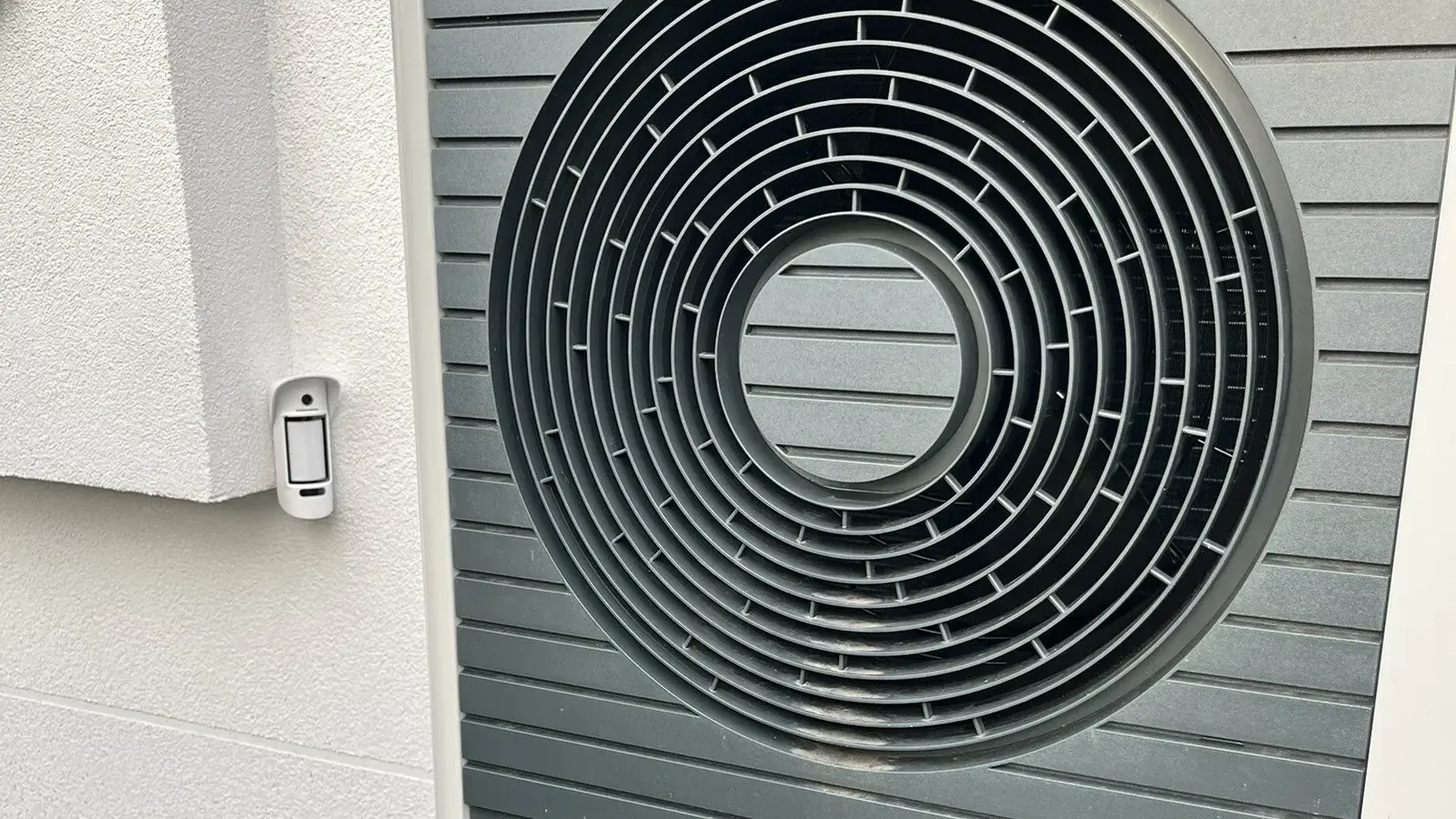 Aussenbewegungsmelder mit Kamera am Haus Aussenbewegungsmelder mit Kamera an der Hauswand neben Technik im Garten
