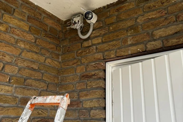 Vorbereitete Leitungsführung für eine Kamera an einer Backsteinwand