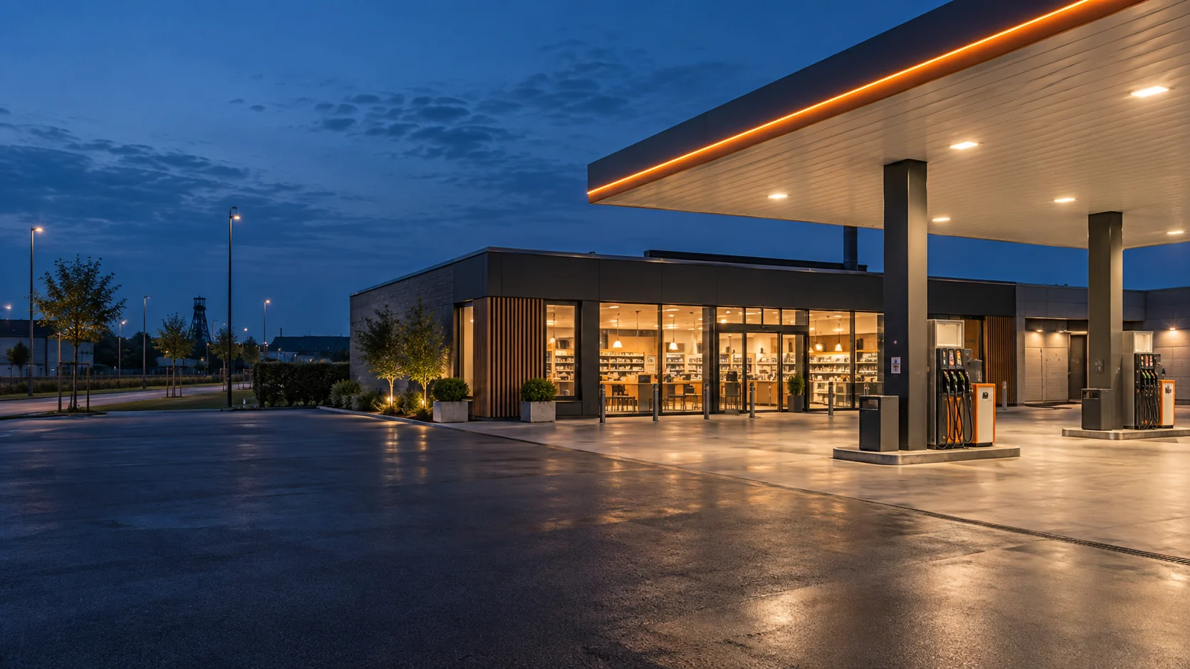 Tankstelle mit Shop, Zapfsäulen und beleuchtetem Vorplatz am Abend